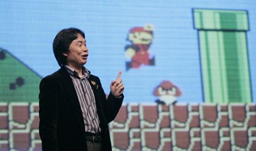 A photo of Shigeru Miyamoto at a seminar with a Super Mario Bros backdrop